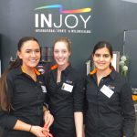 Drei Frauen auf einer Messe vor dem Injoy Stand